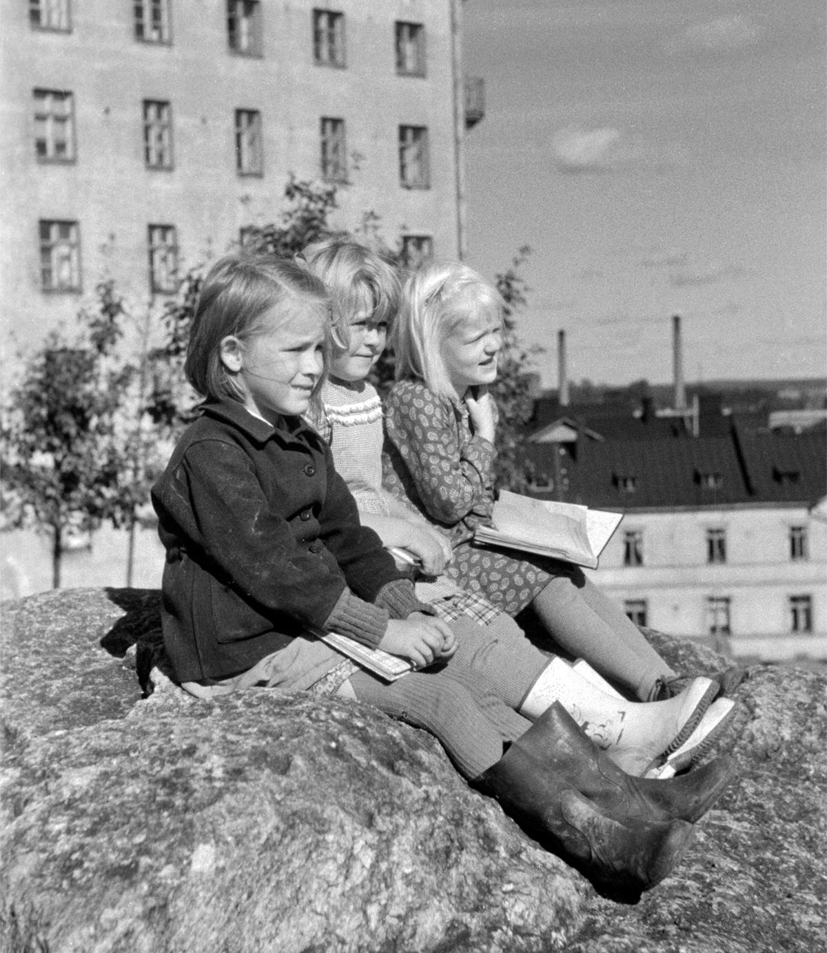 Lapset istuvat Katri Valan puistossa vuonna 1950 lähellä nykyistä Sörnäisten metroasemaa. Paikka oli silloin lähempänä merta kuin nyt. Kuva Eino Heinonen, Helsingin kaupunginmuseo.